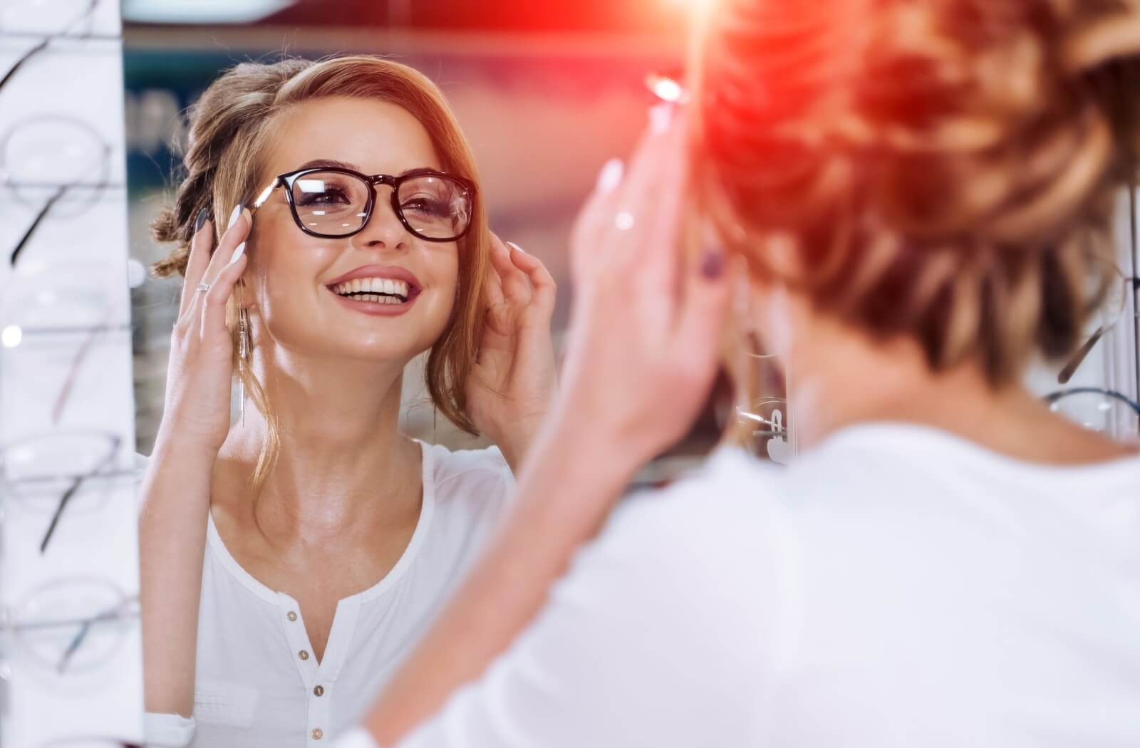 A young girl is trying new glasses in an eye care clinic. 