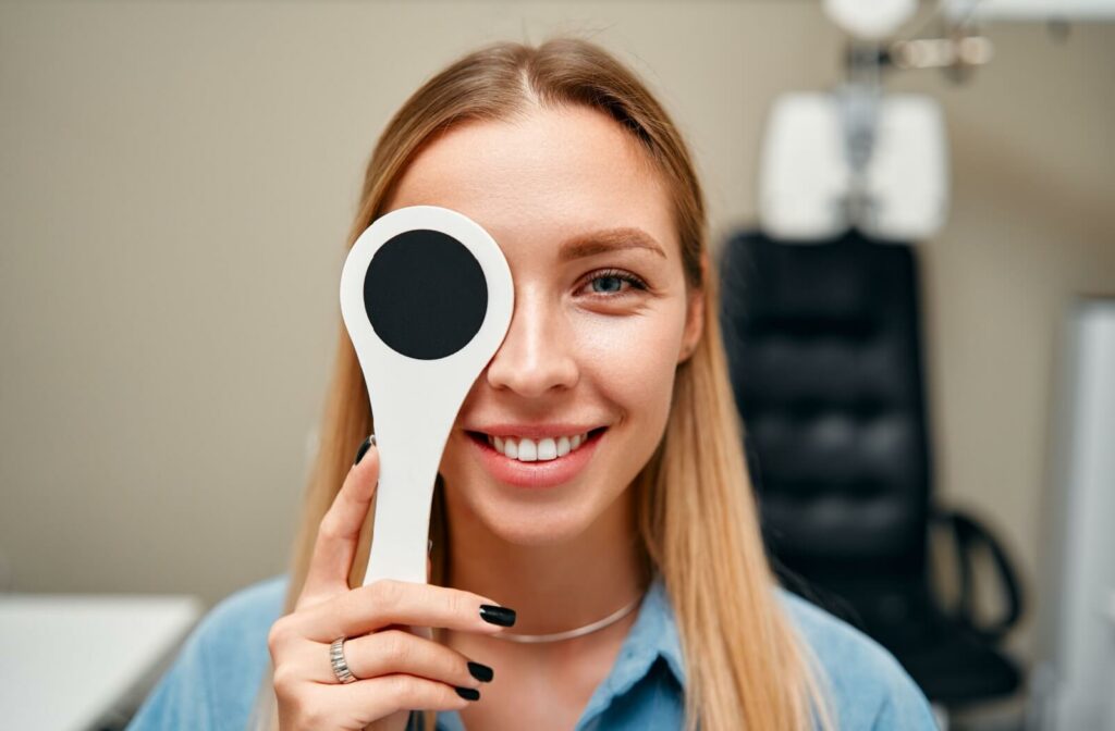 a patient holding an eye cover during their eye exam.
