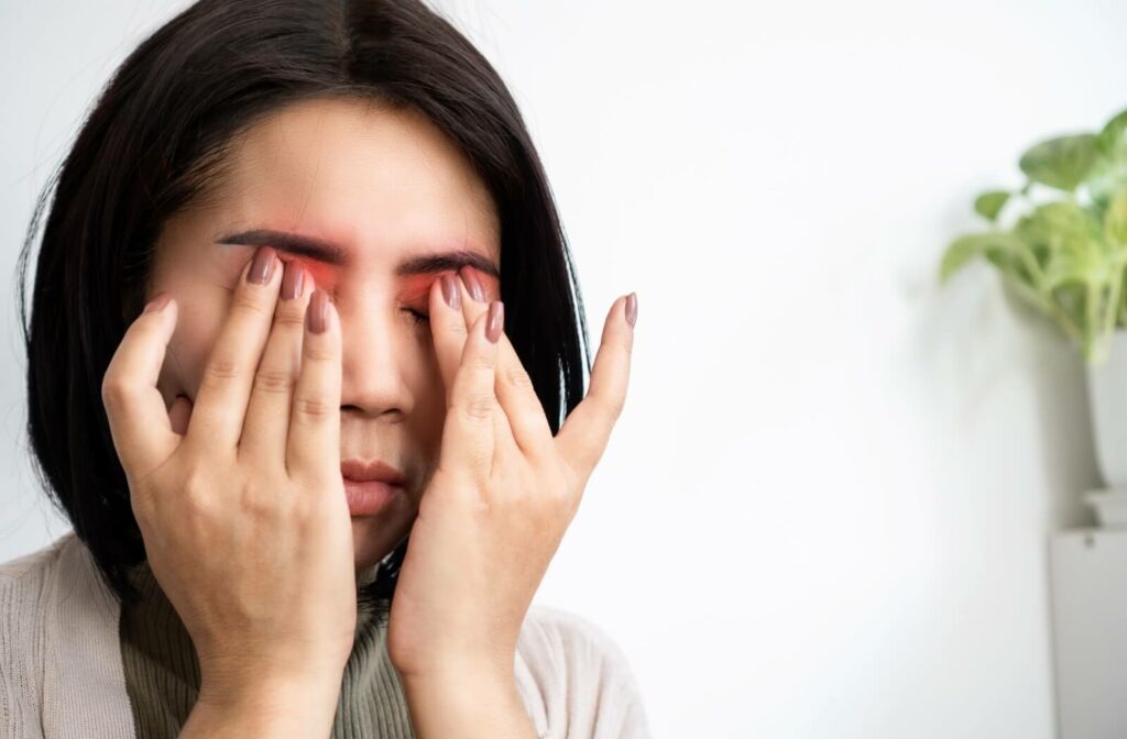 A person with dry eye closes their tired, irritated eyes and gently rubs their eyes with their hands.